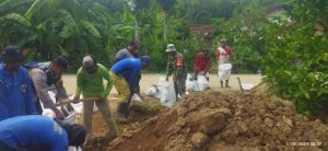 Antisipasi Banjir, Bhabinkamtibmas Desa Angkatan Lor Bersama Warga Kerja Bakti Pembuatan Tanggul Sungai